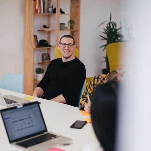 smiling man beside writing person